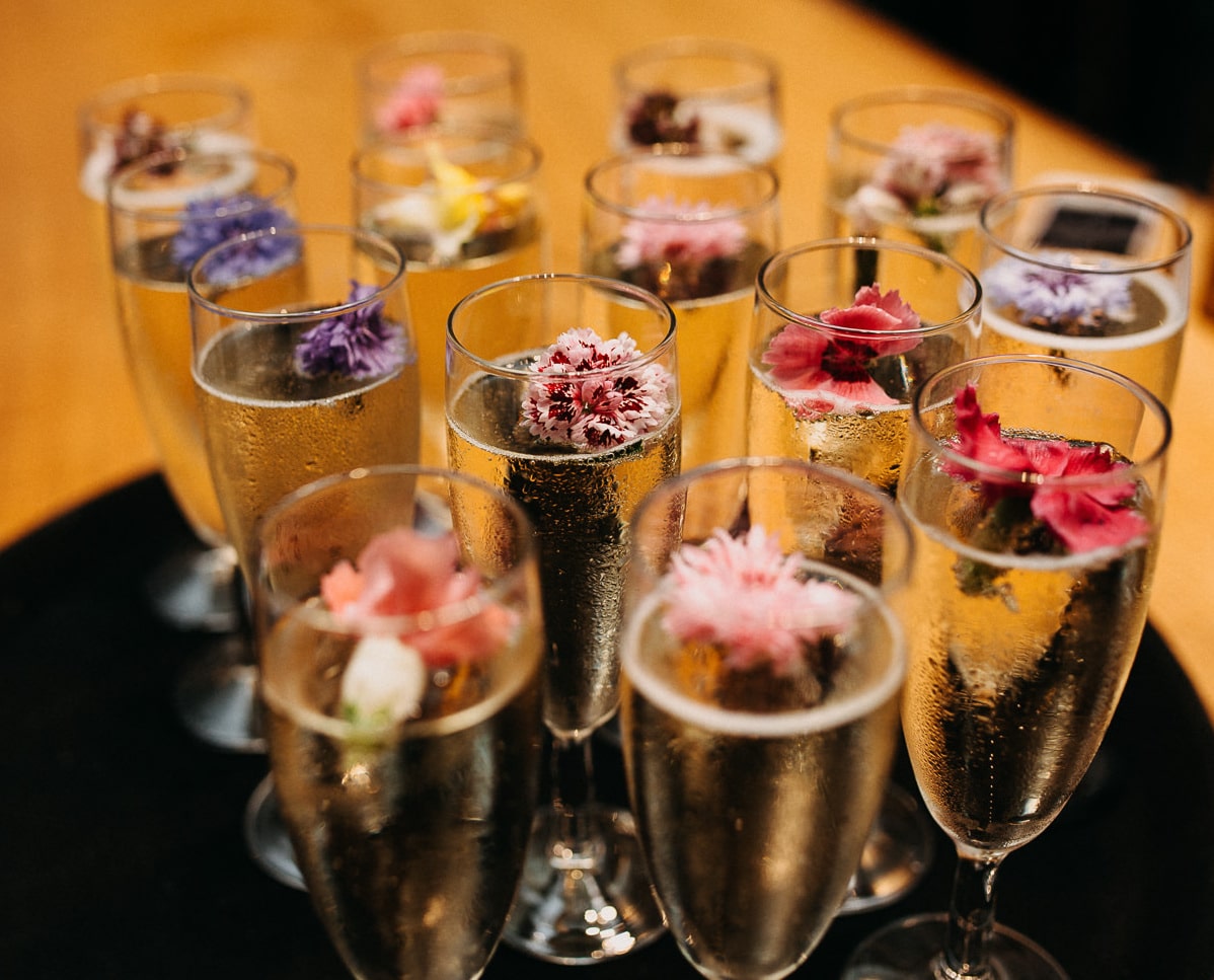 Champagne glasses decorated with pretty flowers Wedding Drinks at South Farm