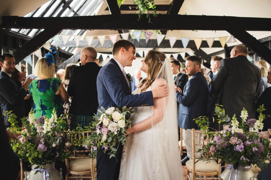 Bride and Groom just married in black timber framed barn