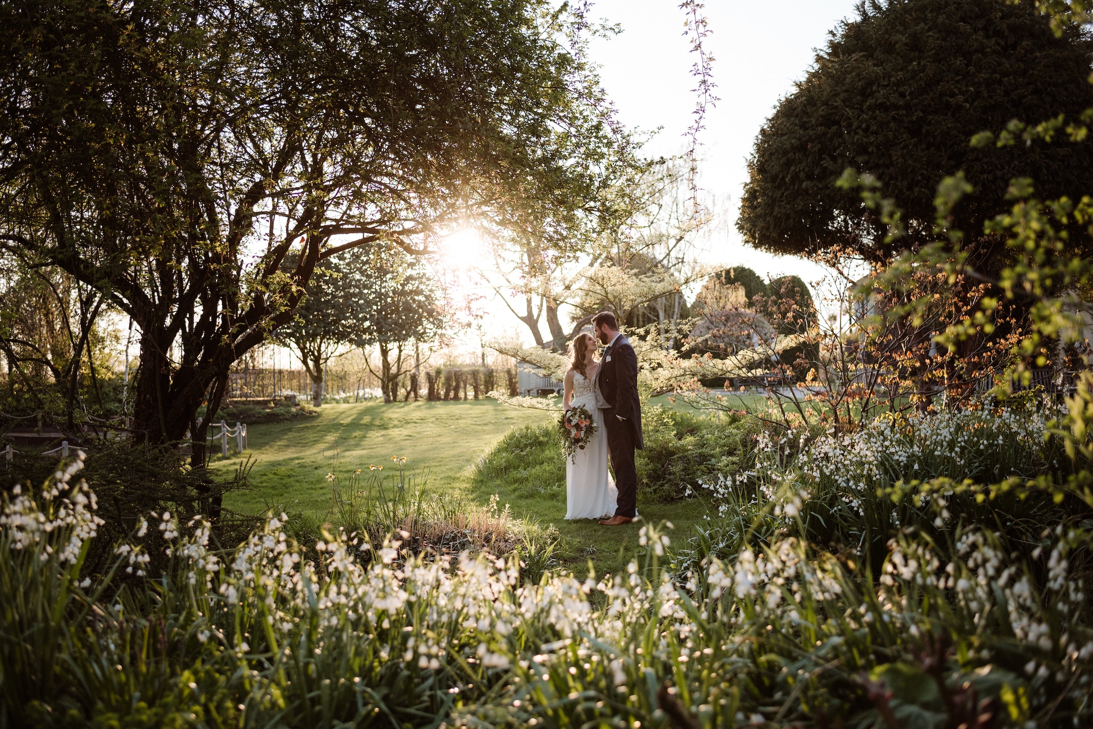 Bride and groom in pretty spring garden at countryside wedding venue
