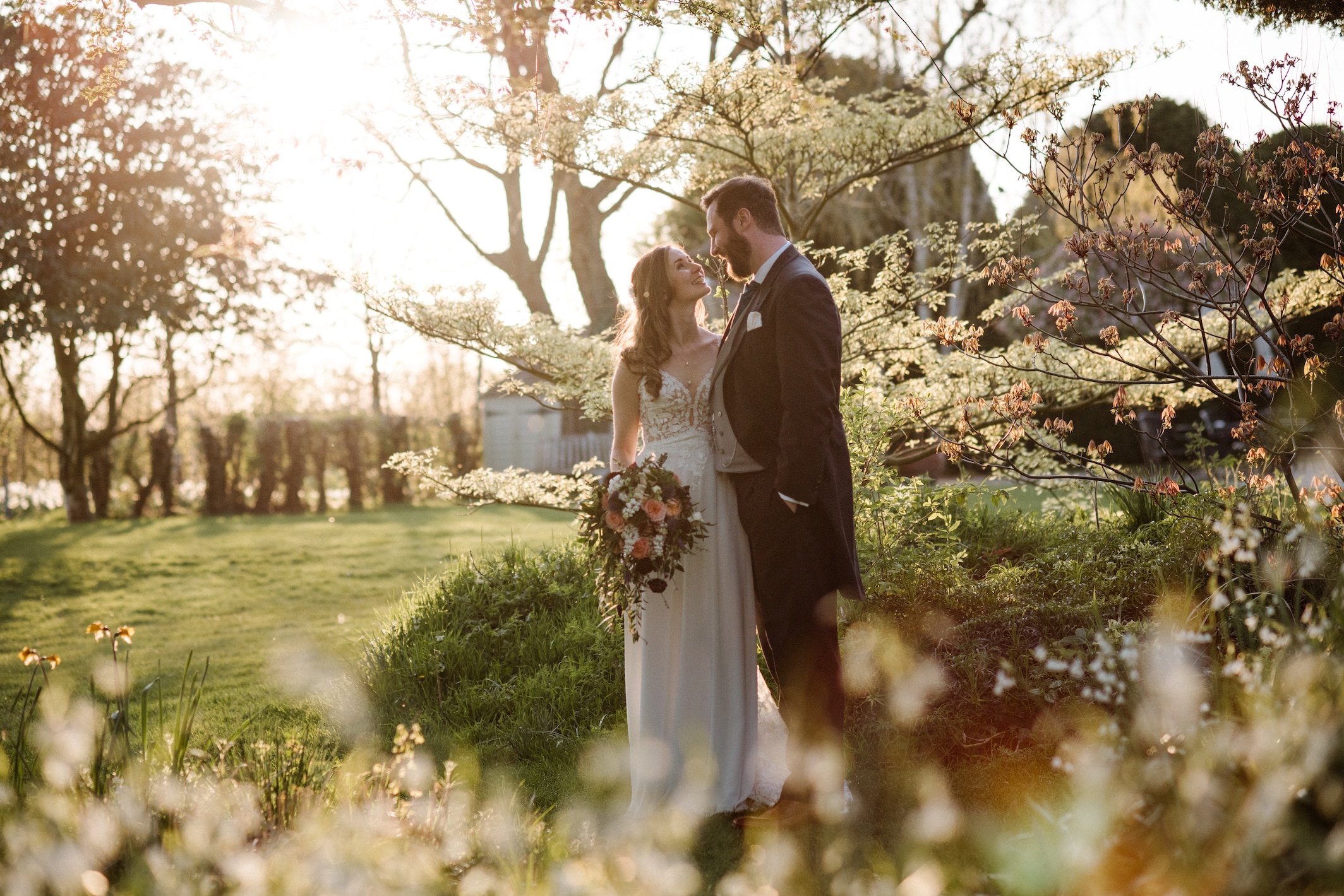 Bride and groom in beautiful spring garden and countryside wedding venue