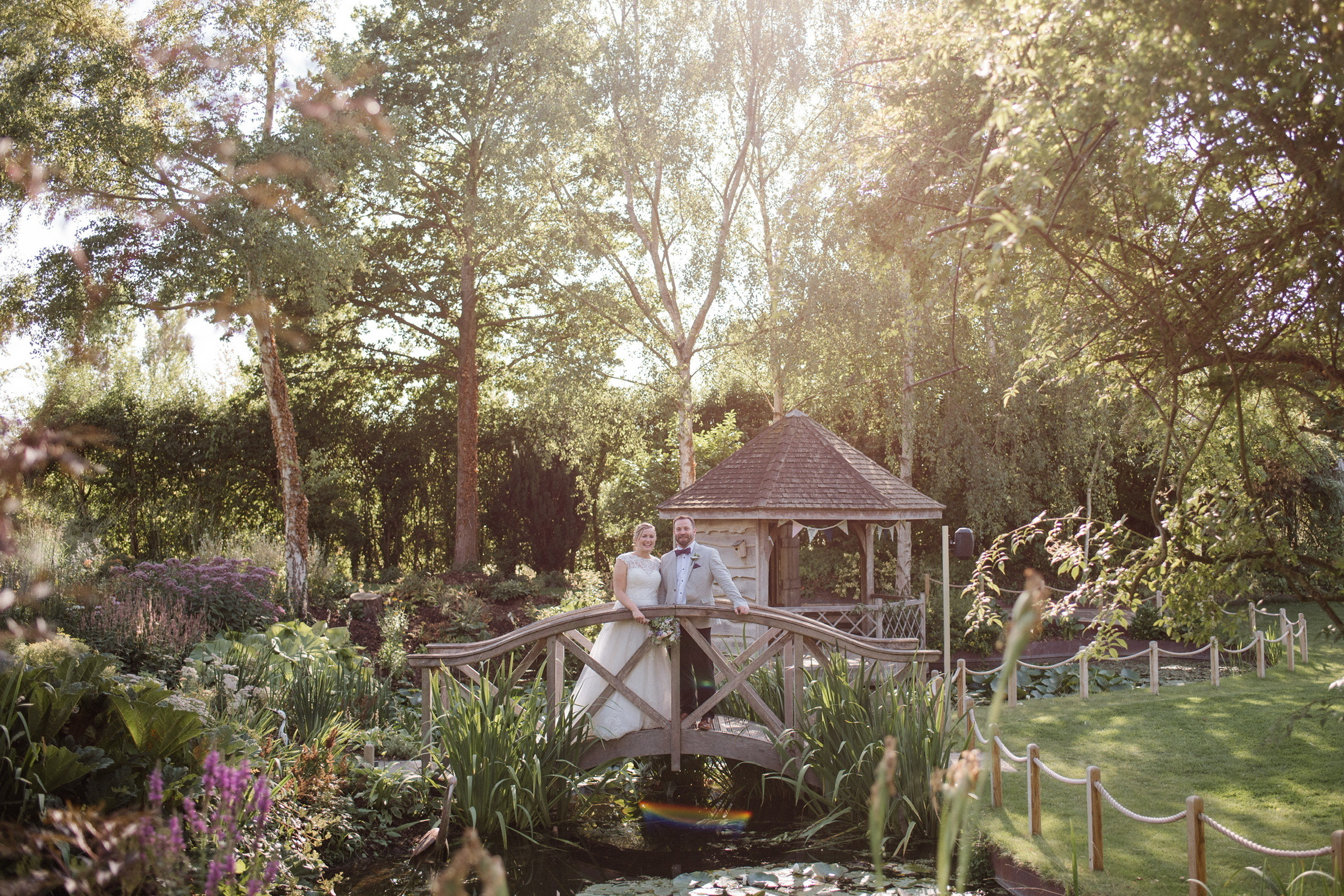 Bride and groom on bridge of countryside wedding venue