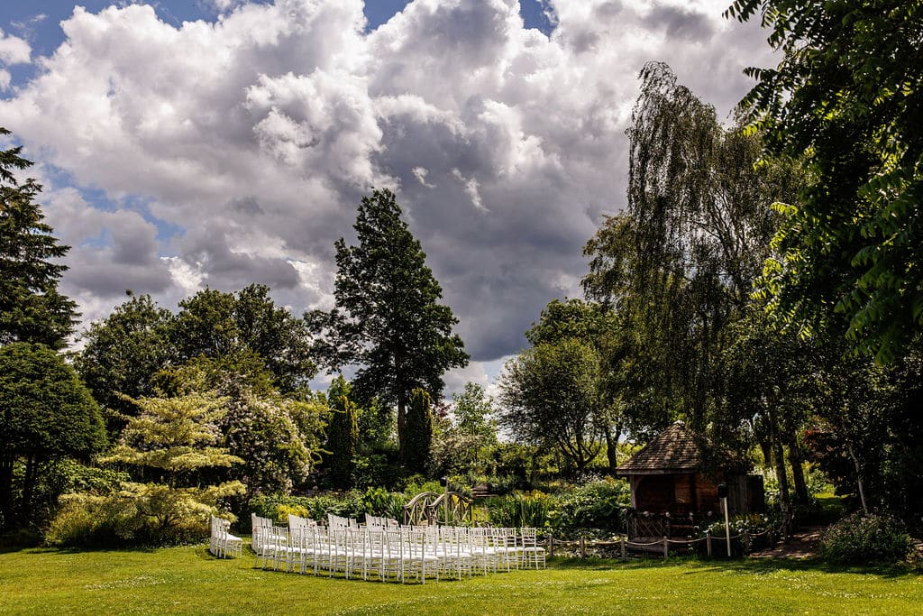 Spring wedding at garden wedding venue garden set for ceremony with white chairs