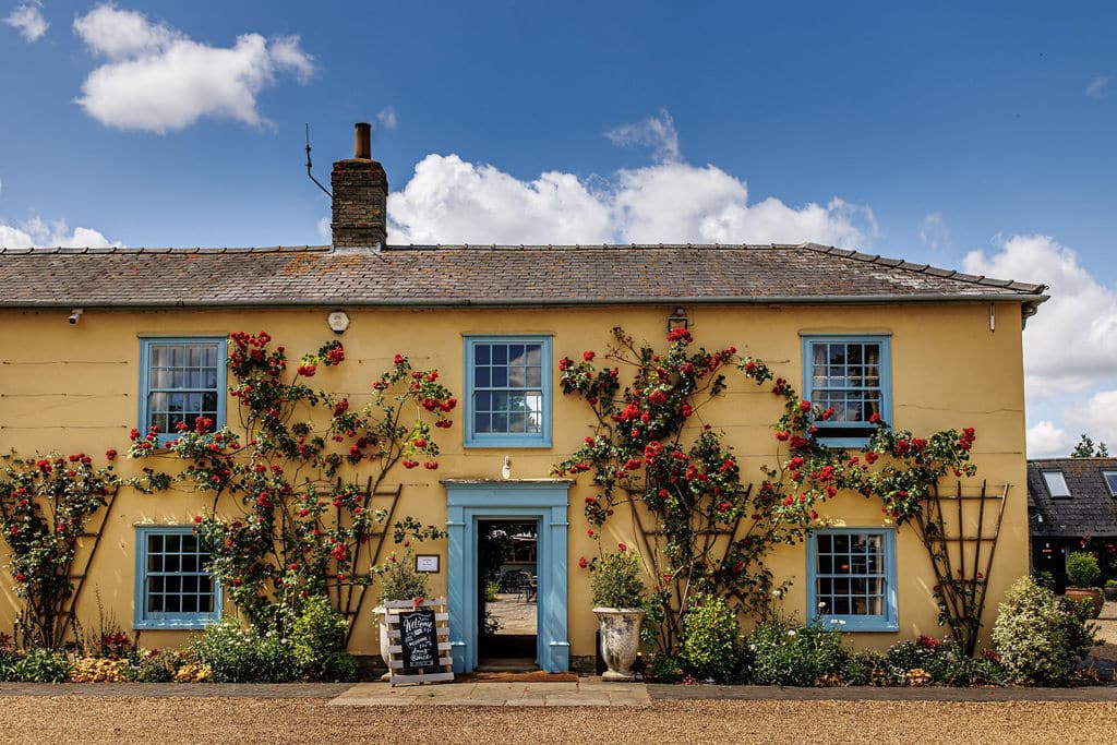 Countryhouse wedding venue Cream farmhouse with blue windows and doors