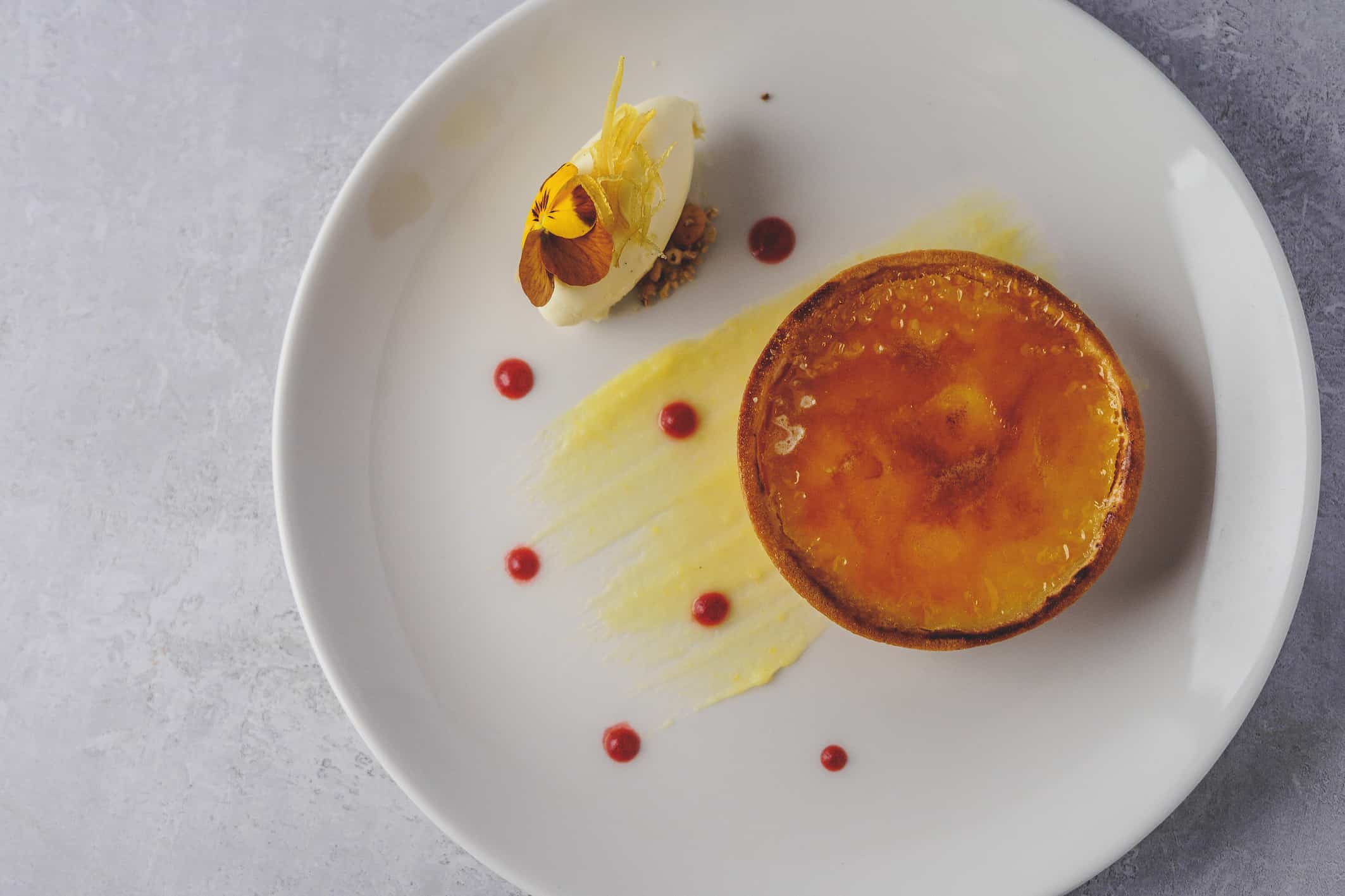 Pastry tart served at wedding venue with home made vanilla ice cream and decorated with edible flowers