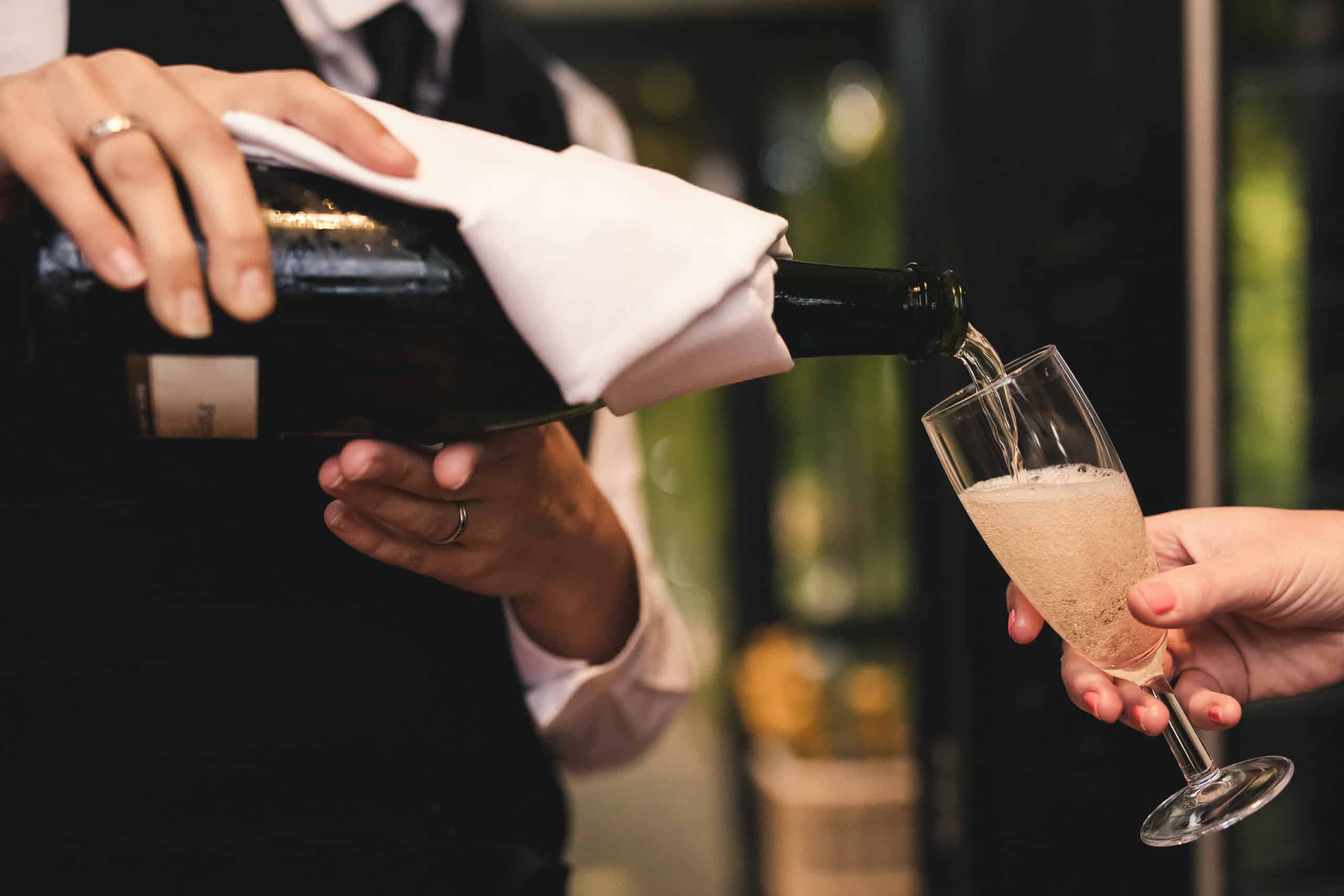 Pouring Champagne for Wedding Guest at South Farm