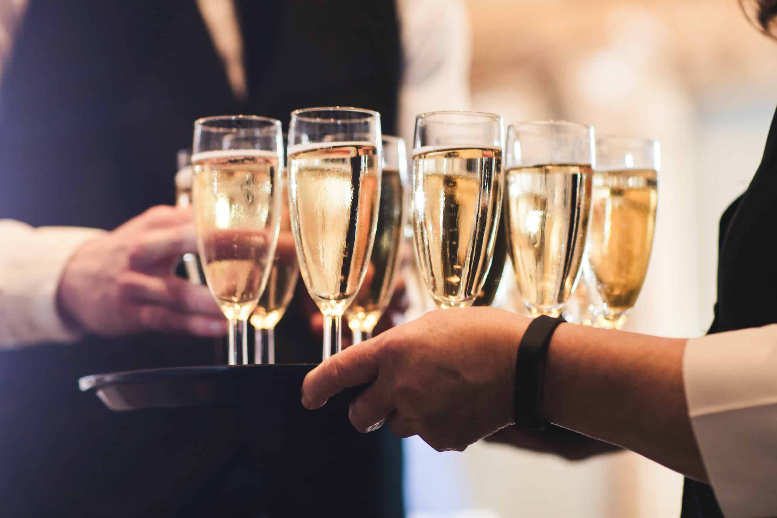 Champagne being tray served at wedding venue