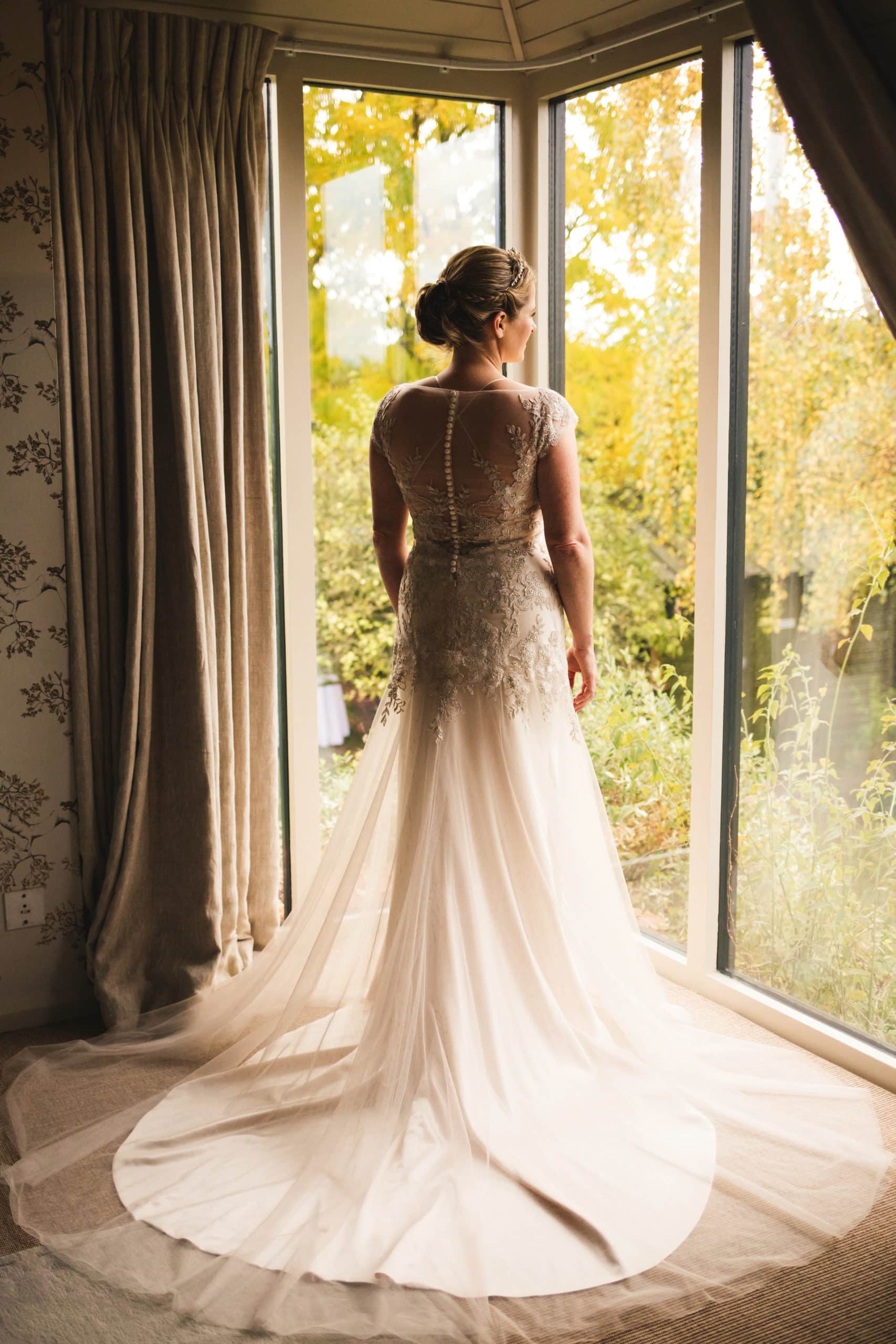 Beautiful Bride in Bridal Gown at window of Bridal Suite Farm Wedding Venue