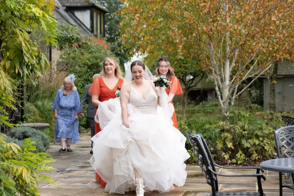 Bride, bridesmaids and mother of the bride walking on sunset terrace at gorgeous countryside wedding venue based in Hertfordshire