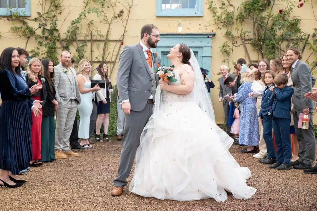 Bride and Groom having a confetti shot at the front of charming Farmhouse in the Hertfordshire countryside