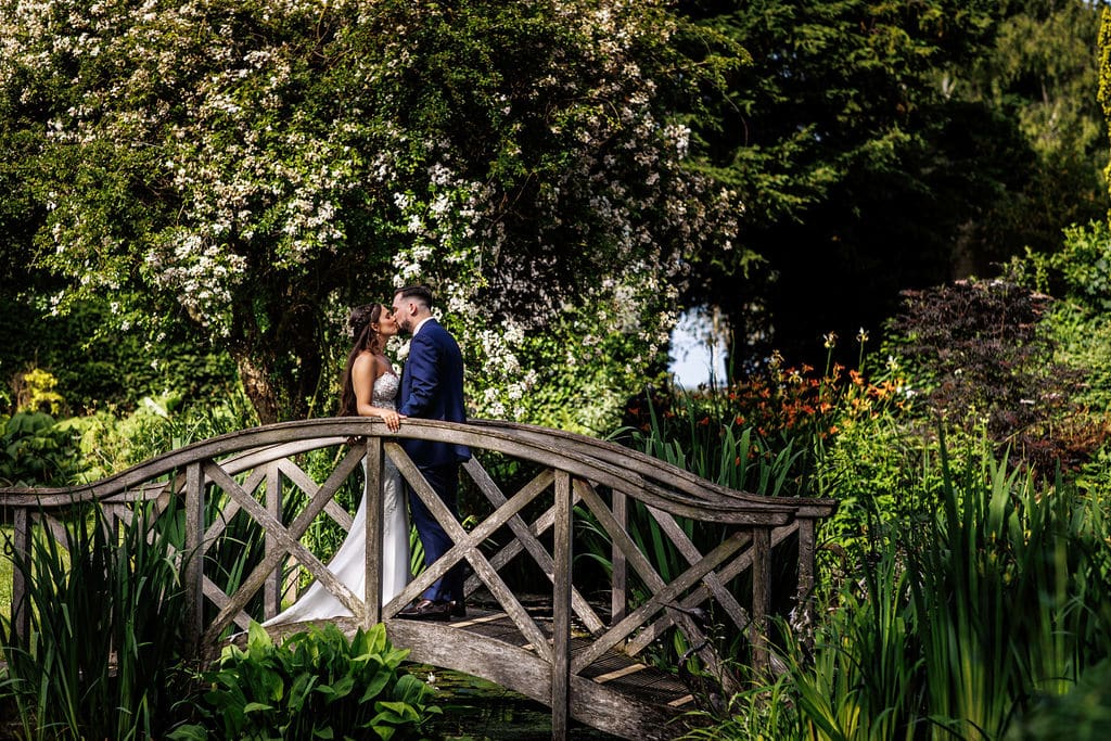 Bride and groom share a kiss at countryside garden wedding venue