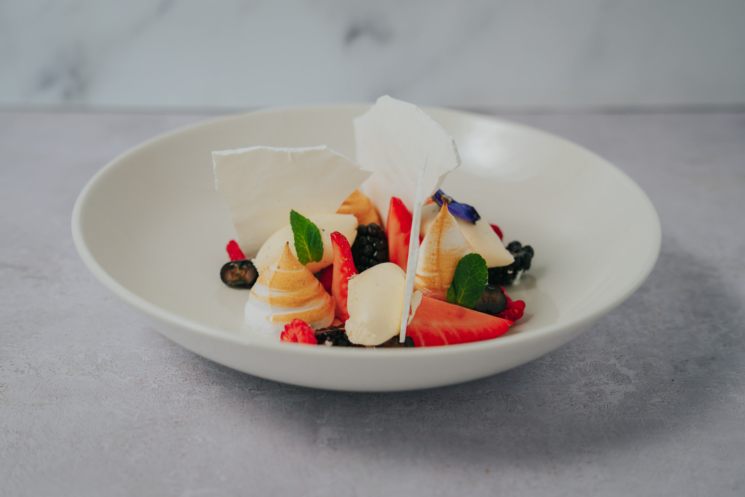 Photo of deconstructed eton mess with meringue and colourful fruit plated at award winning wedding venye