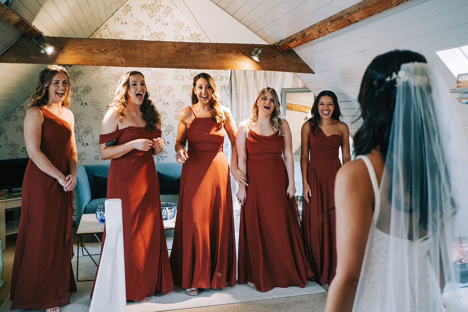 Bridesmaids in beautiful terracotta coloured dresses see Bride on wedding day for first time in luxury wedding accomodation