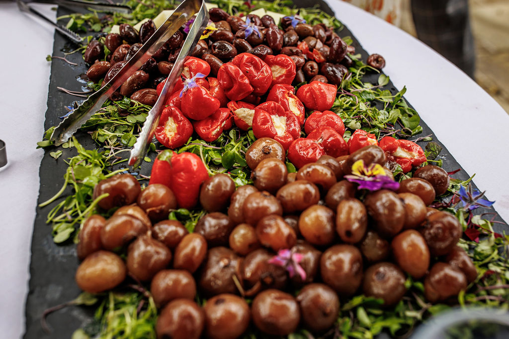 Olives, Stuffed Peppers and green salad on an antipasti sharing board at field to fork wedding venue