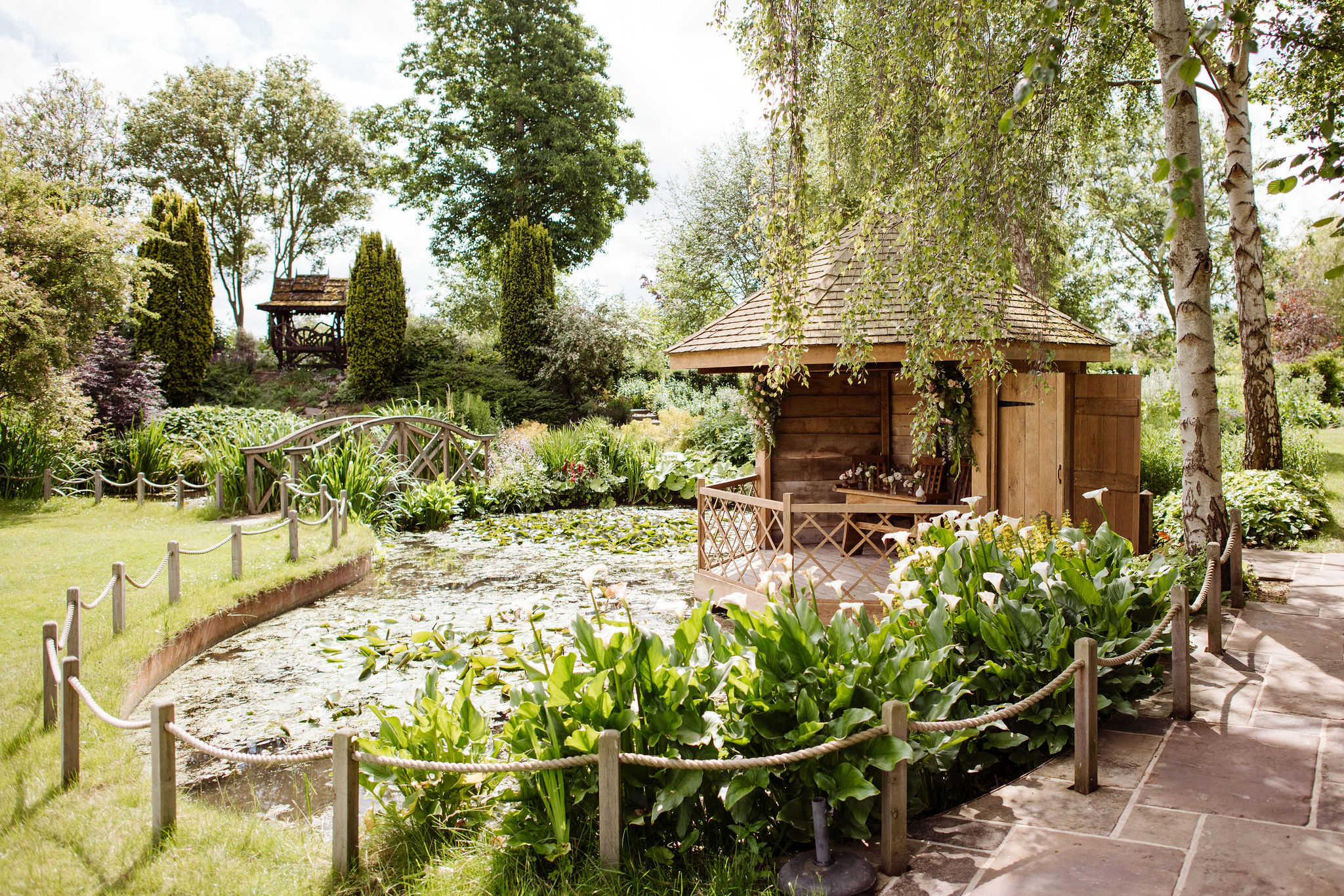 Garden summerhouse set by pond at countryside wedding venue on a sunny day