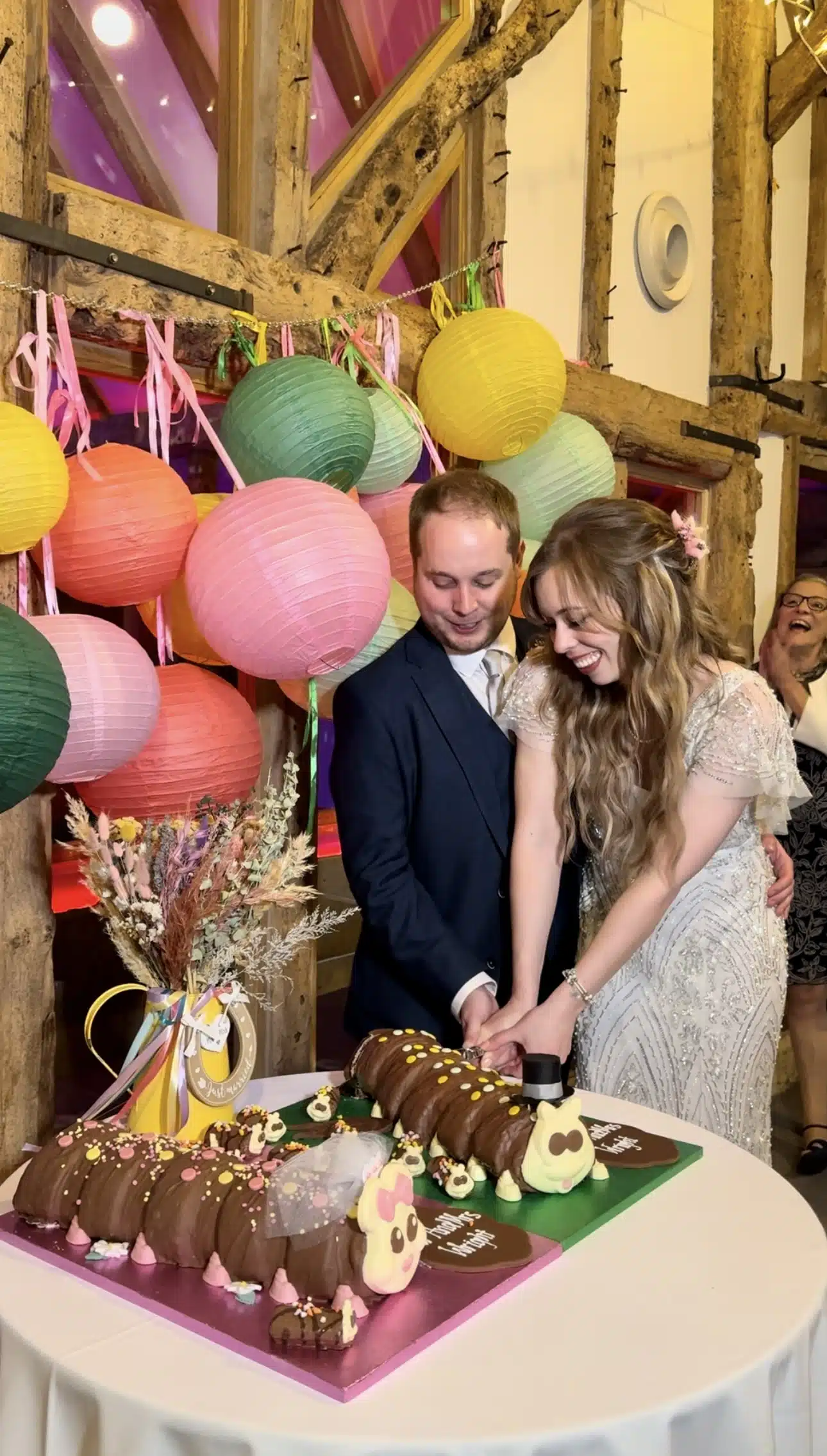 Bride and Groom cutting their 'Colin Caterpillar' cake in the Tudor Barn