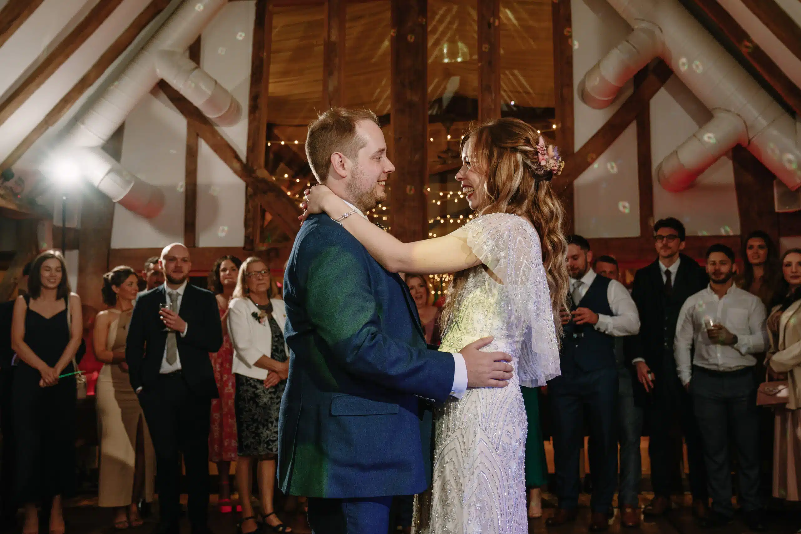 Bride and Groom having their first dance in the Horse Barn with all of their guests surrounding them