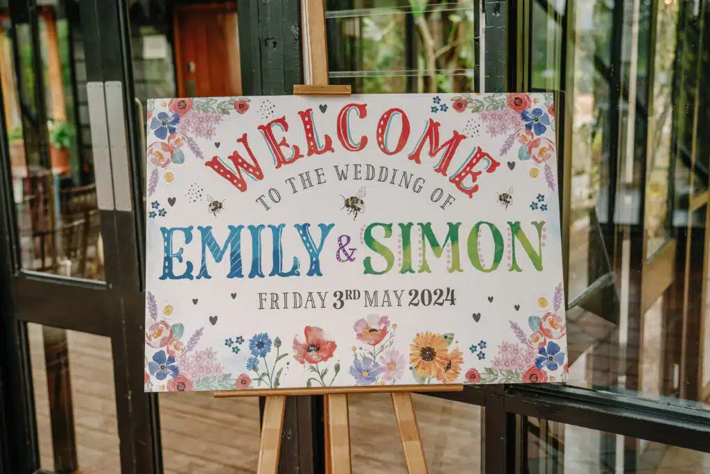 Colourful wedding welcome sign in the Old Dairy at barn wedding venue