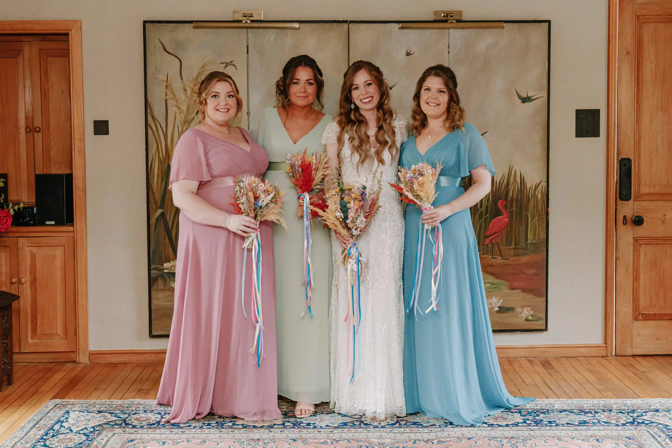 Bride and her Bridesmaids having a group photo in the Drawing Room at South Farm wedding venue