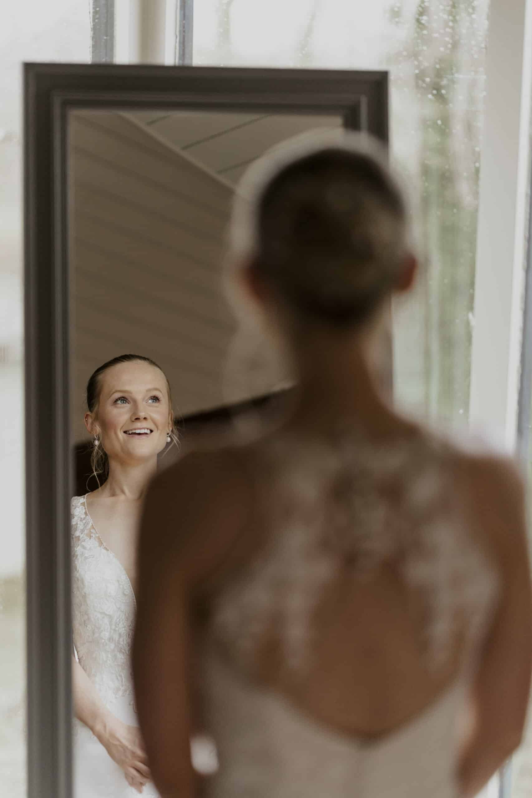 Bride having a special moment standing in front of the mirror in the Coach House Suite / Bridal Suite admiring her wedding dress 