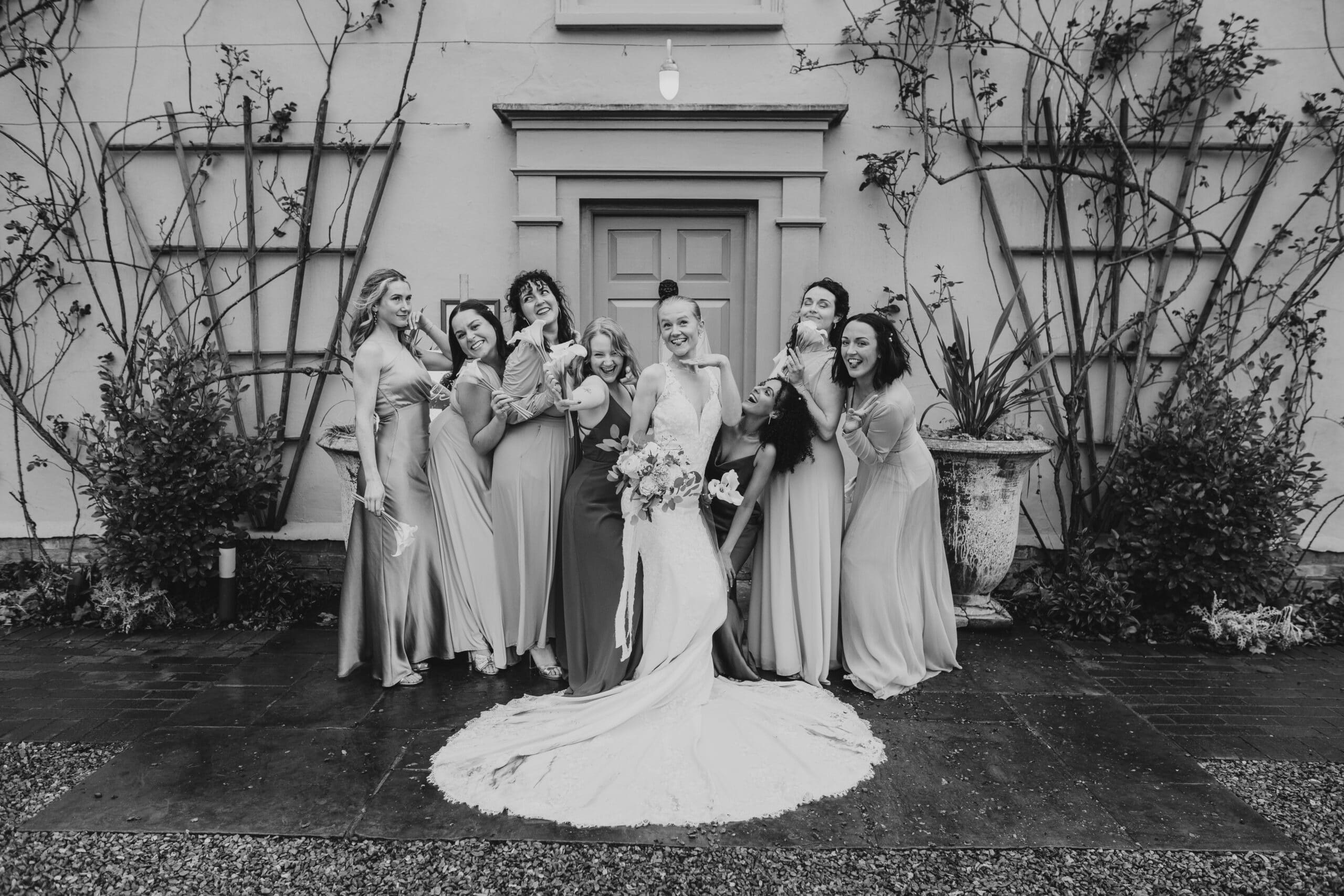 Bride and her Bridesmaids having fun group photo at the front of South Farm's charming farmhouse 