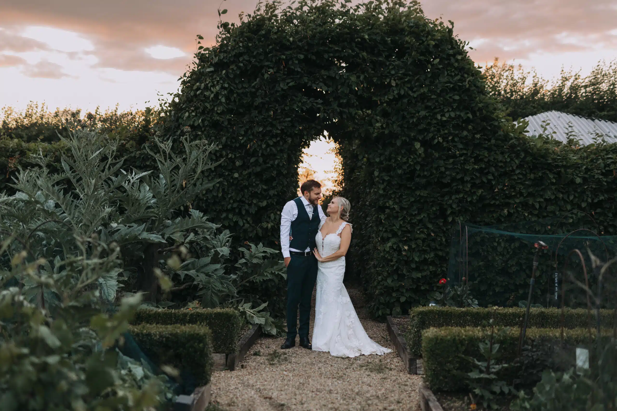 Bride and Groom standing in the Kitchen Garden at eco friendly wedding venue