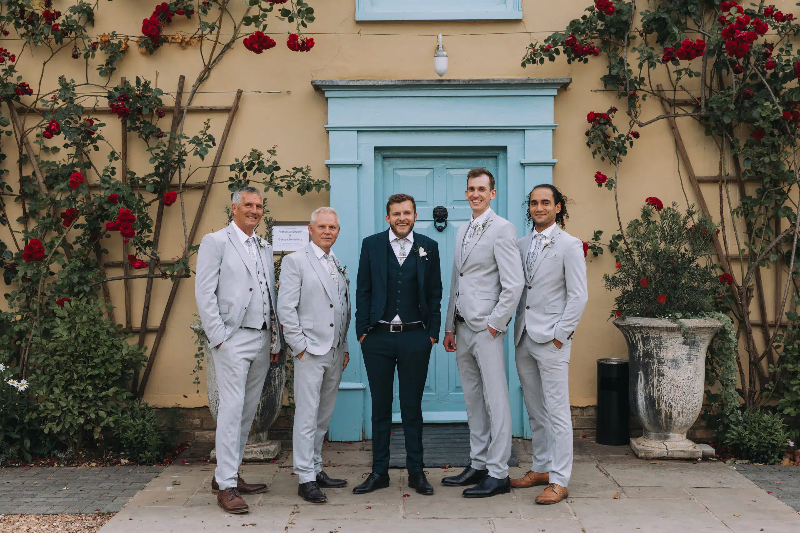 Groom and Groomsmen having group photo front of South Farm's Farmhouse