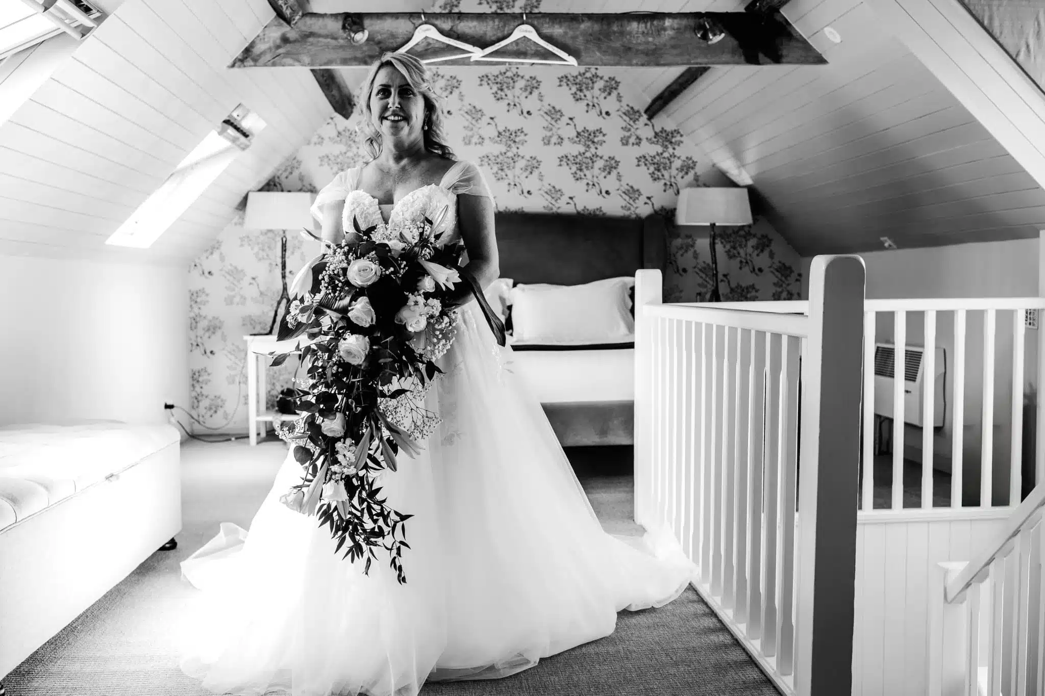 Bride in her white wedding dress in the Coach House Suite holding a big bouquet of flowers moments before saying I do