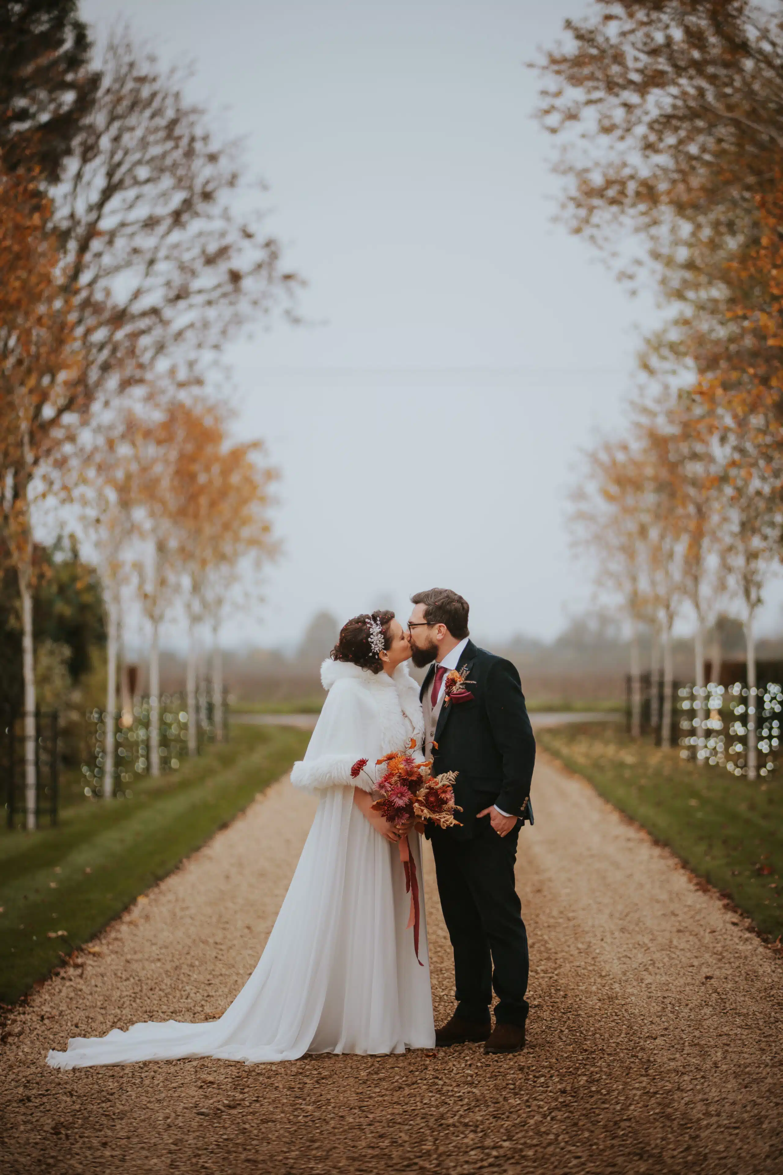 Bride in her white dress and groom enjoying a special moment down the star-lit driveway at Cambridgeshire wedding venue