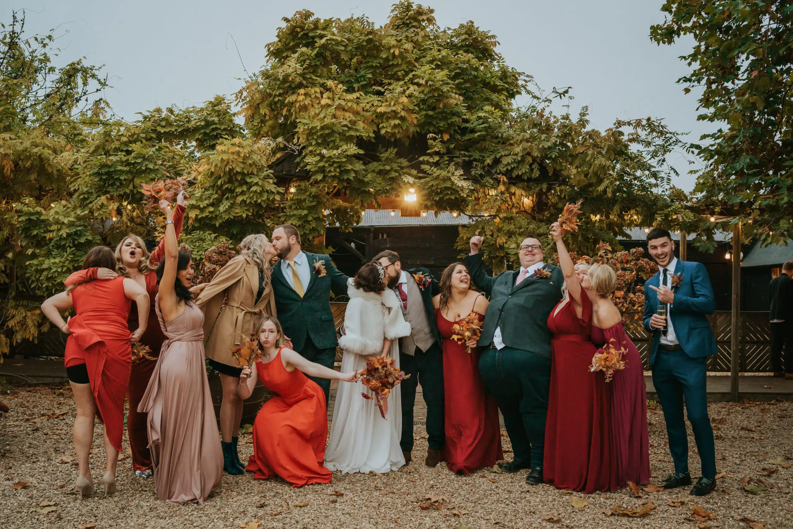 Bride and Groom having a fun group photo in the Courtyard at countryside barn wedding venue