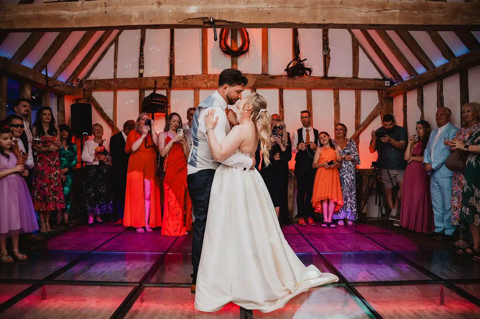 Bride and Groom having their first dance in the rustic Horse Barn with all of their guests surrounding them