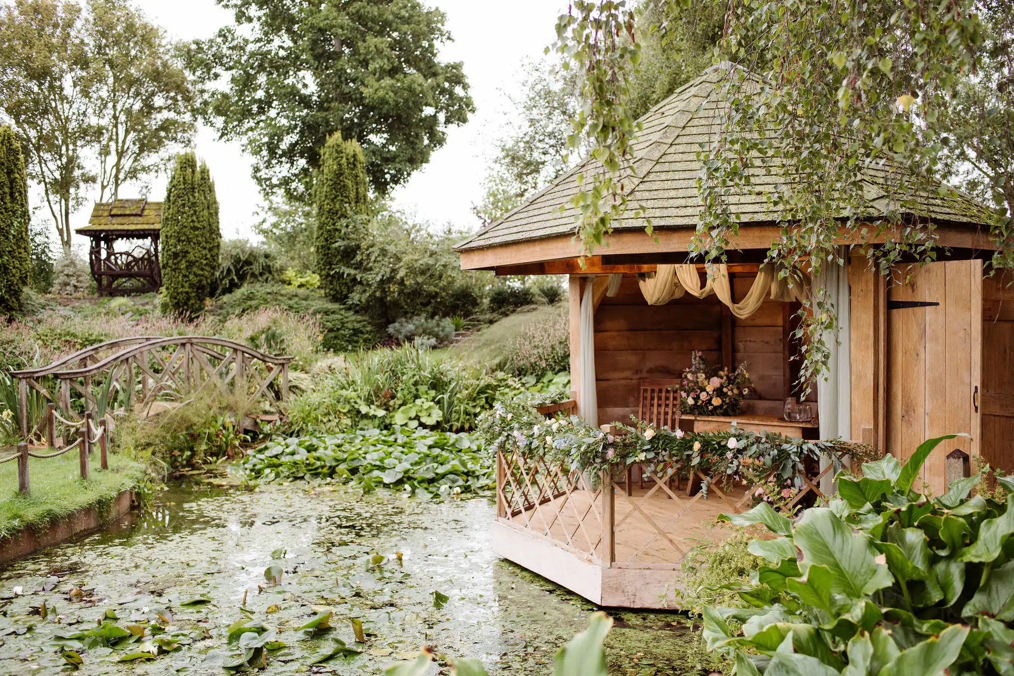 Gorgeous outdoor Summerhouse dressed with flowers inn the formal gardens at outdoor garden wedding venue