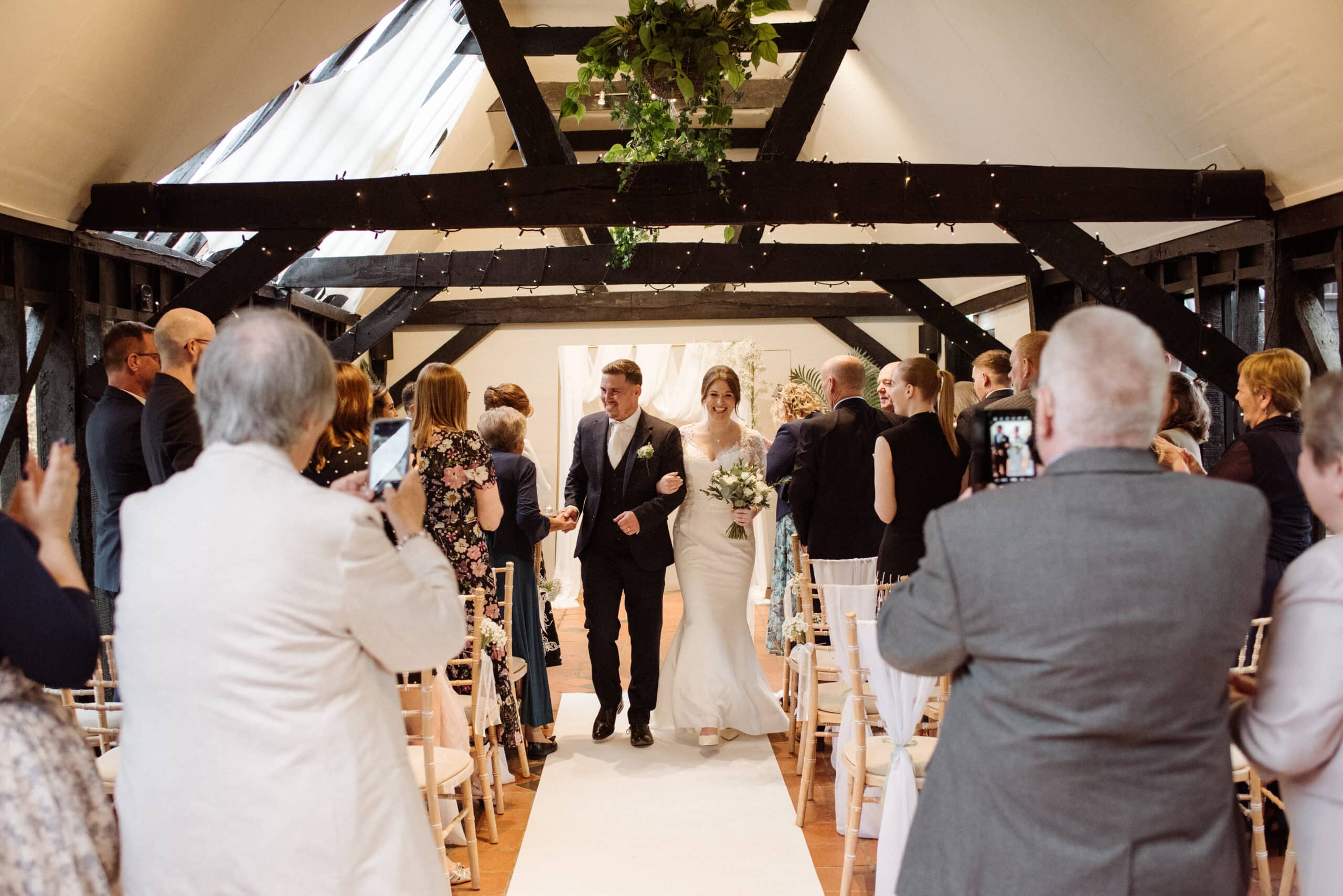 Bride and Groom walking down the aisle in the Old Dairy after saying I Do