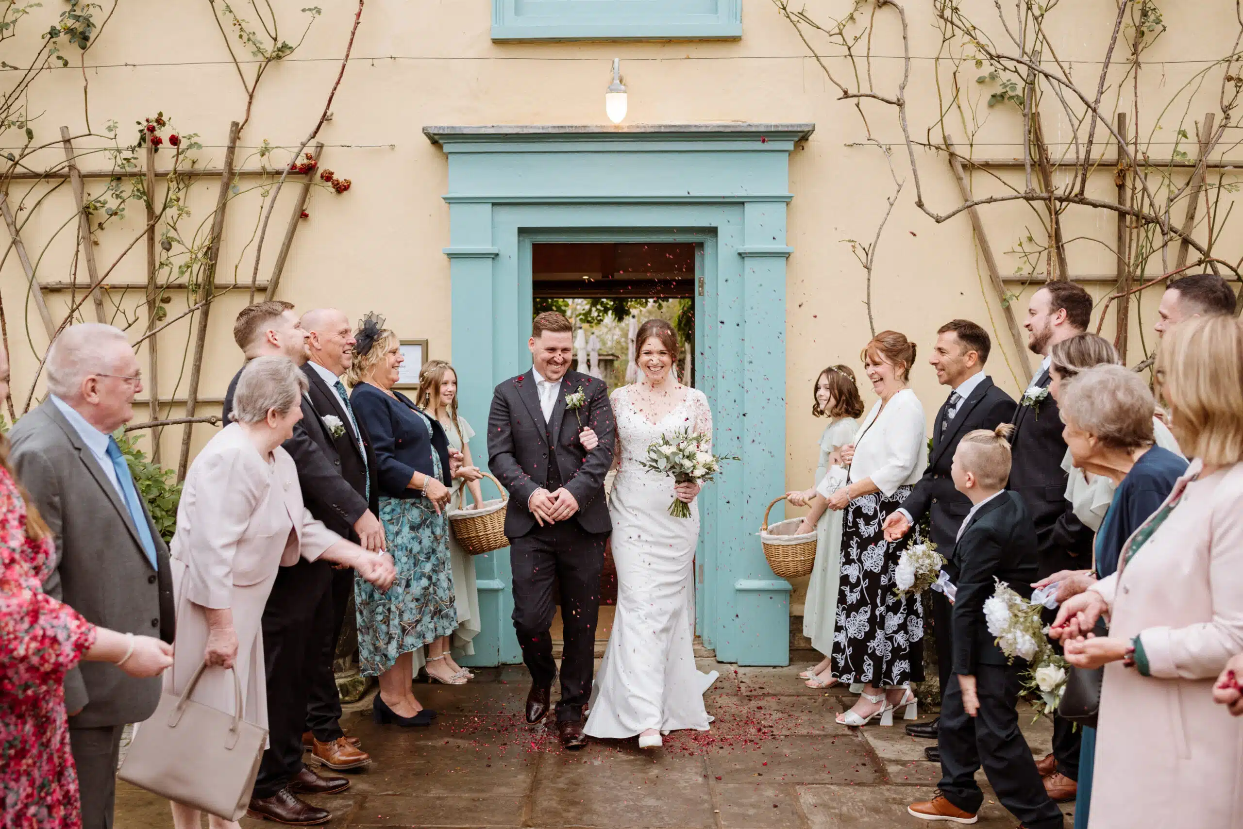 Bride and Groom and enjoying a confetti photo at the front of the Farmhouse at countryside wedding venue