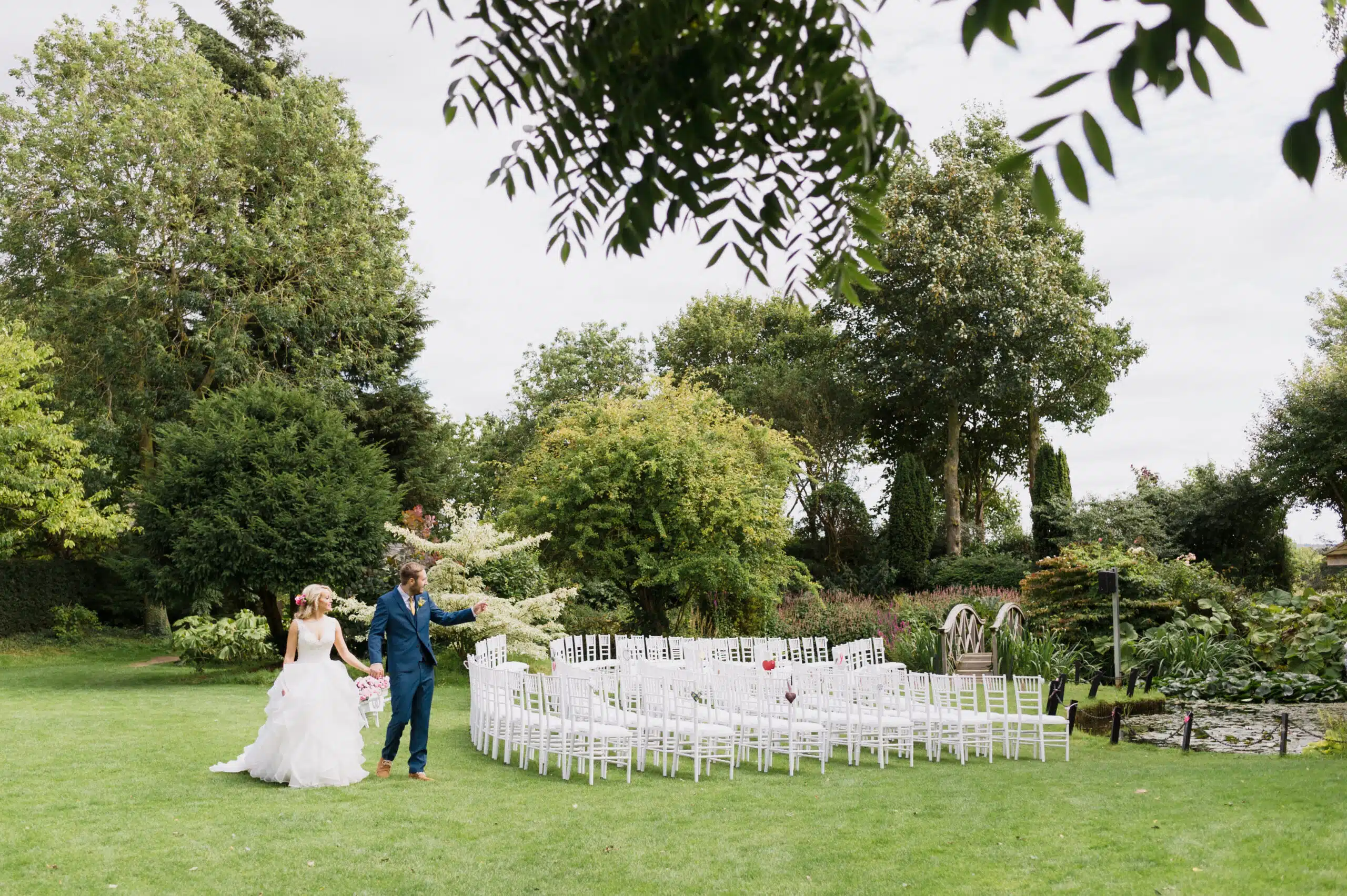 Bride and Groom standing on the lawn near the Summerhouse at outdoor garden wedding venue