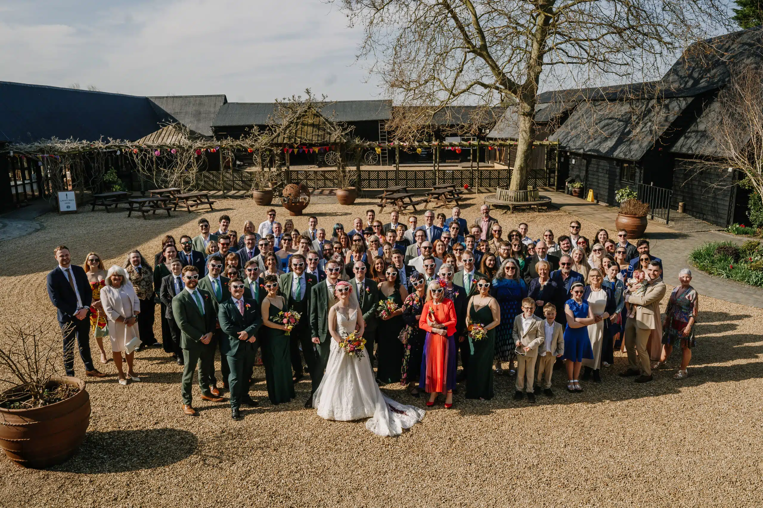 The wedding party having a group photo in the Courtyard at barn wedding venue in Hertfordshire