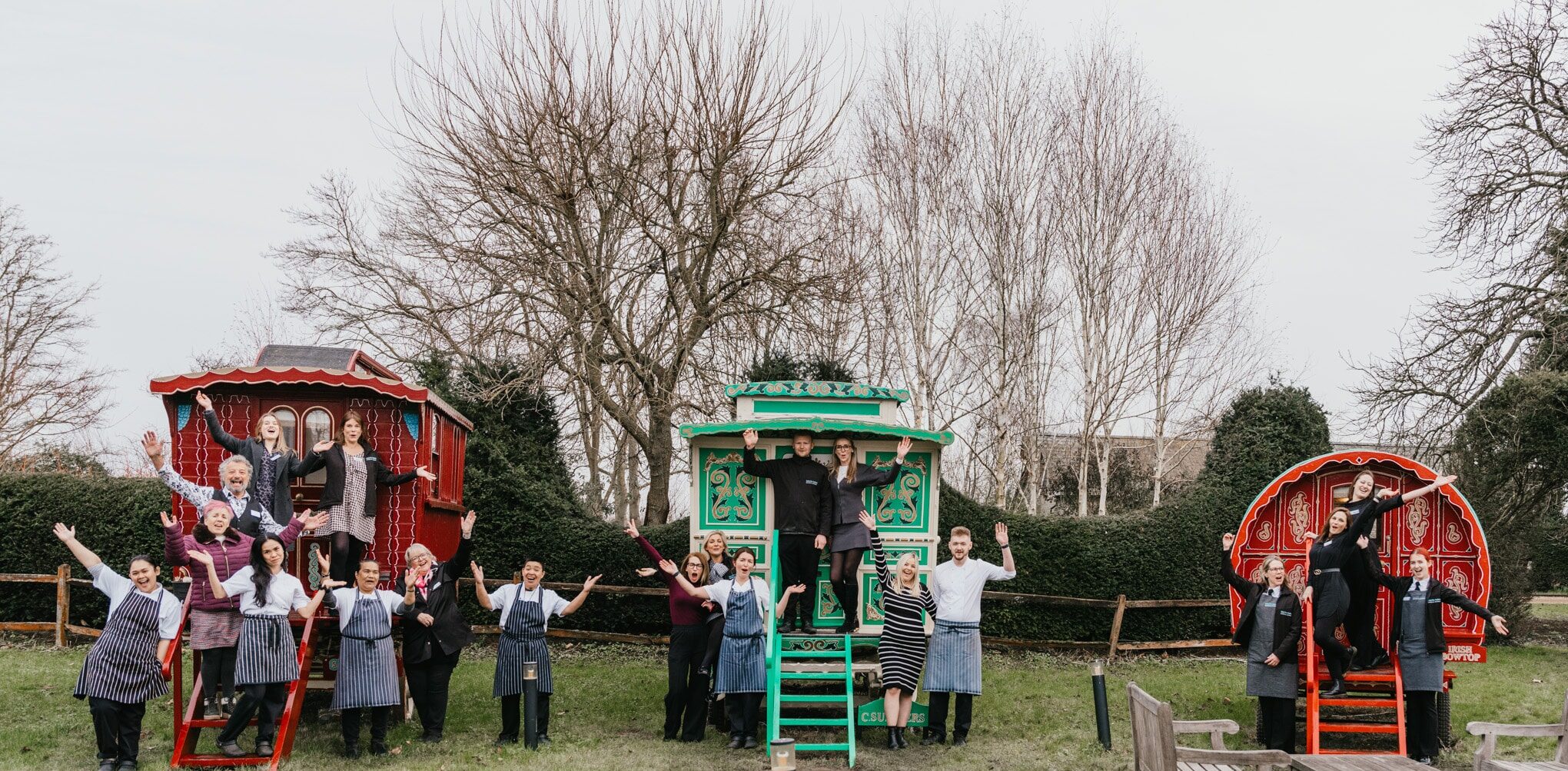 Photo of the South Farm Team on the Romany Caravans with hands in the air at barn wedding venue raising funds for Cancer Research UK