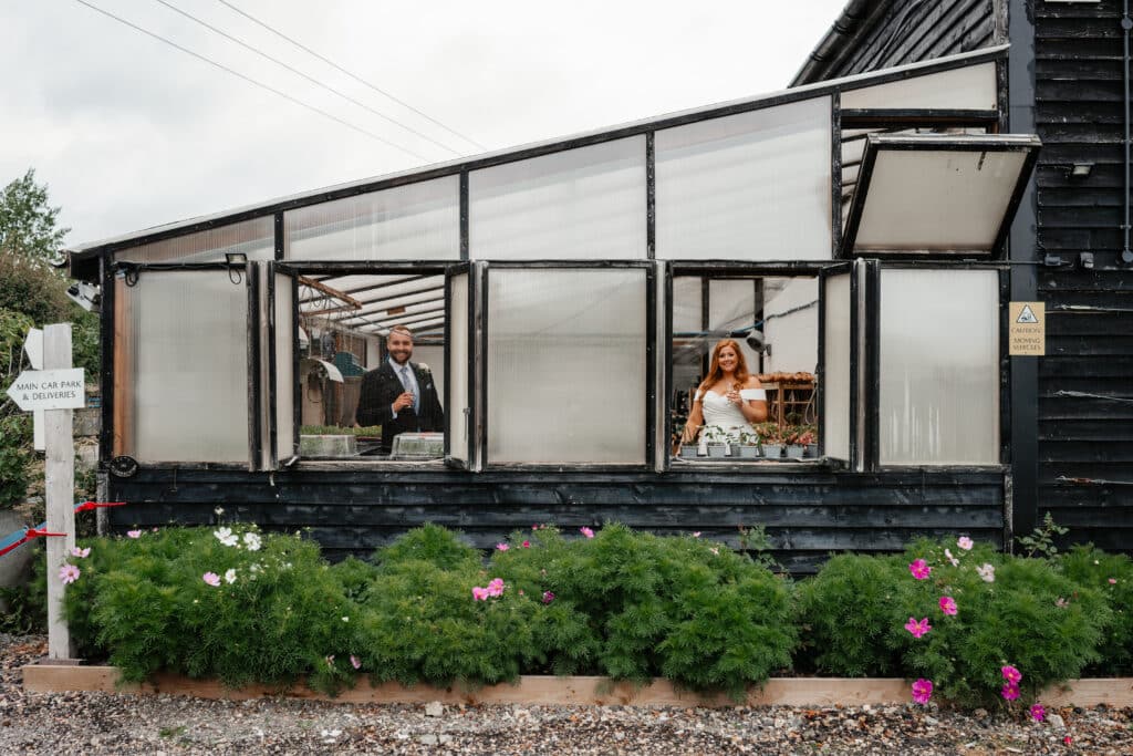Bride and Groom in the polytunnels at eco conscious wedding venue in Hertfordshire