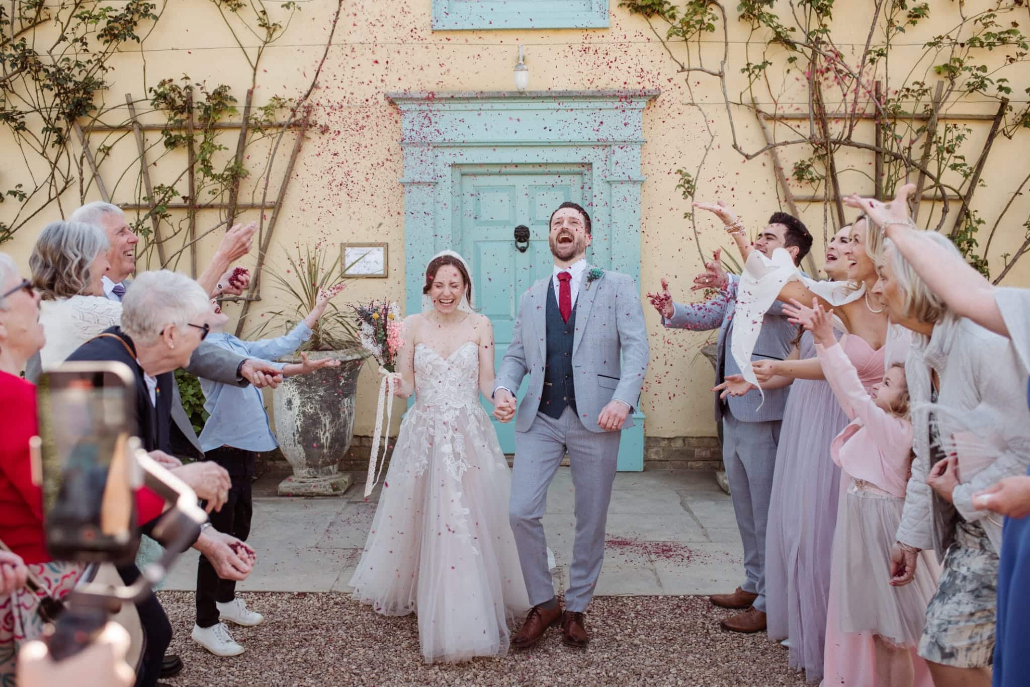 Bride and Groom enjoying their confetti photo at the front of South farm's Farmhouse 