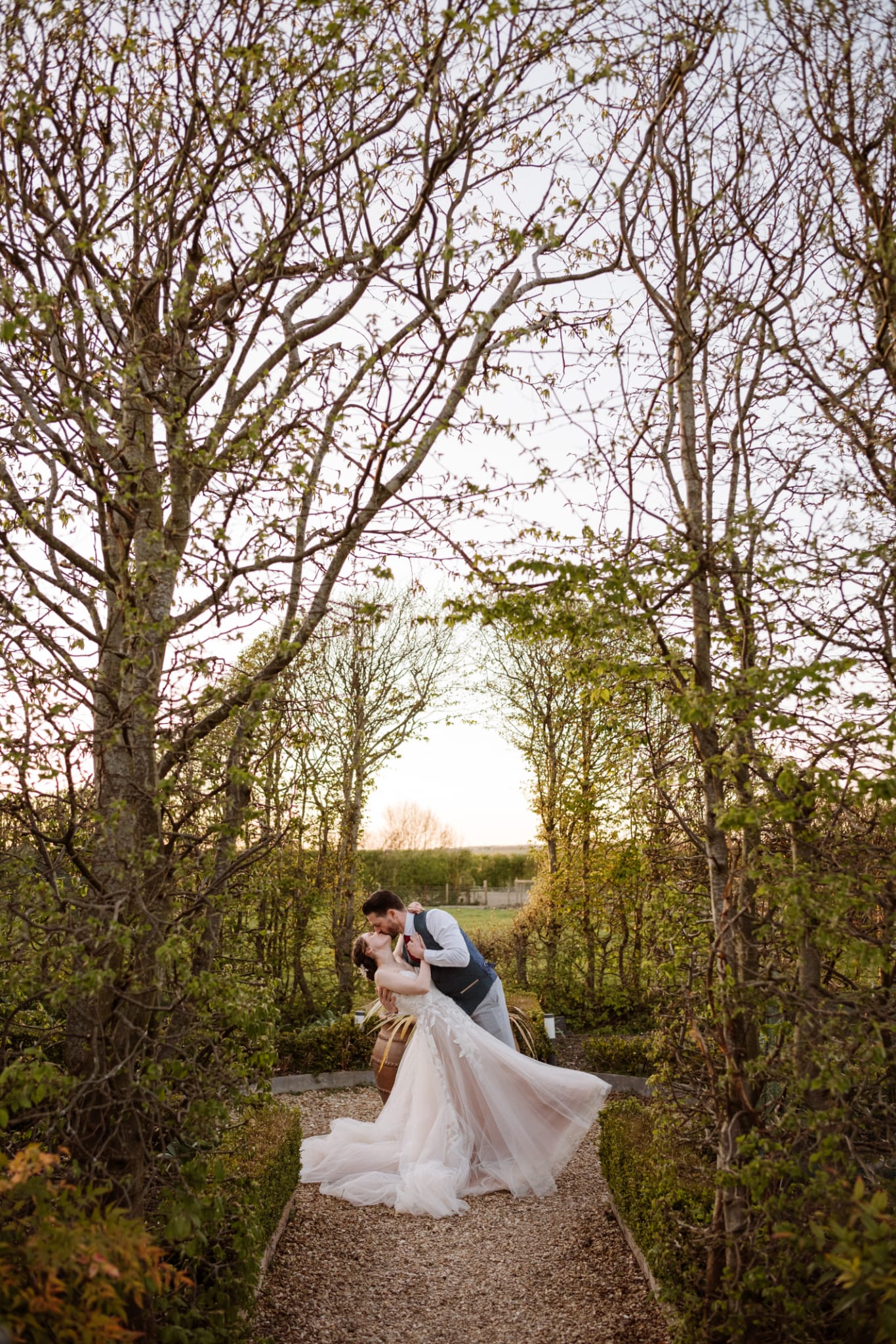 Bride and Groom walking through the Kitchen Garden at eco-conscious wedding venue in Hertfordshire 