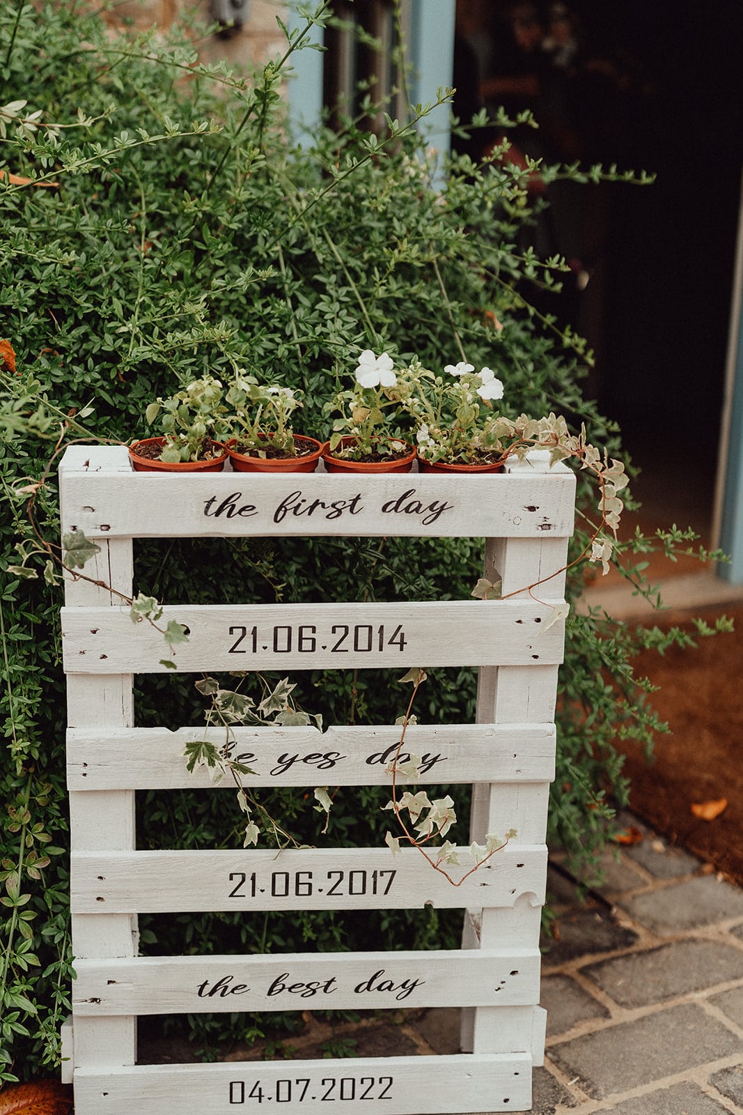 Eco wedding signage, order of the day on a wooden pallet topped with pretty plants