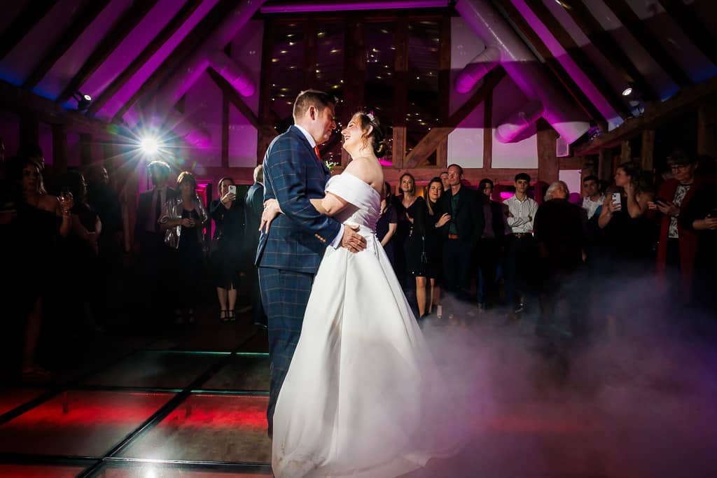 Bride and Groom having their first dance in the Horse Barn at eco conscious wedding venue in Cambridgeshire