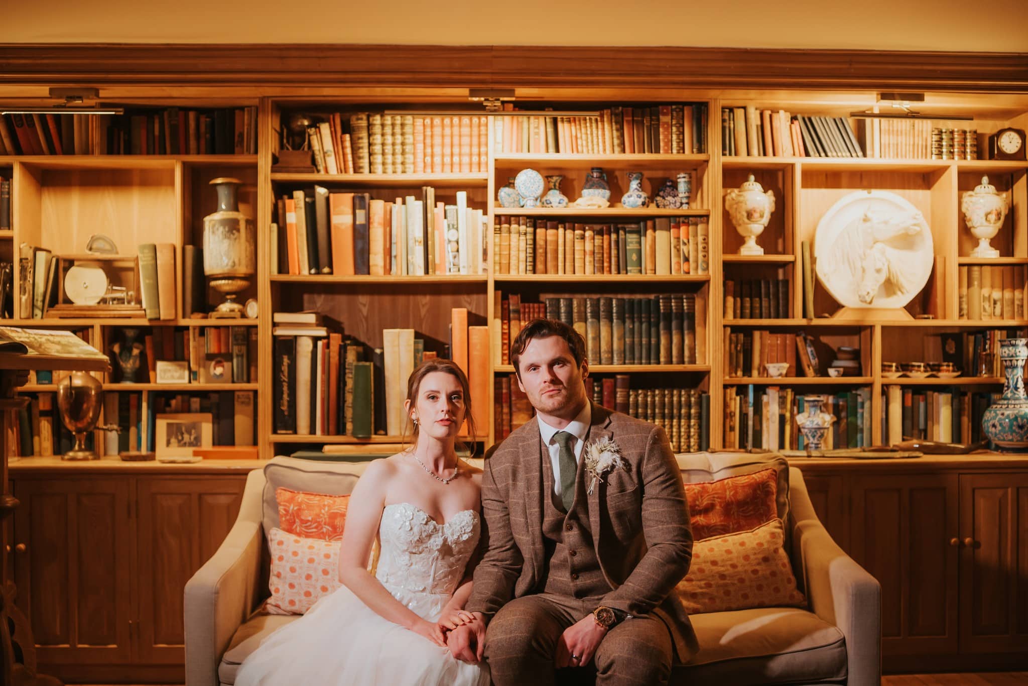 Couple seated in cozy library setting.
