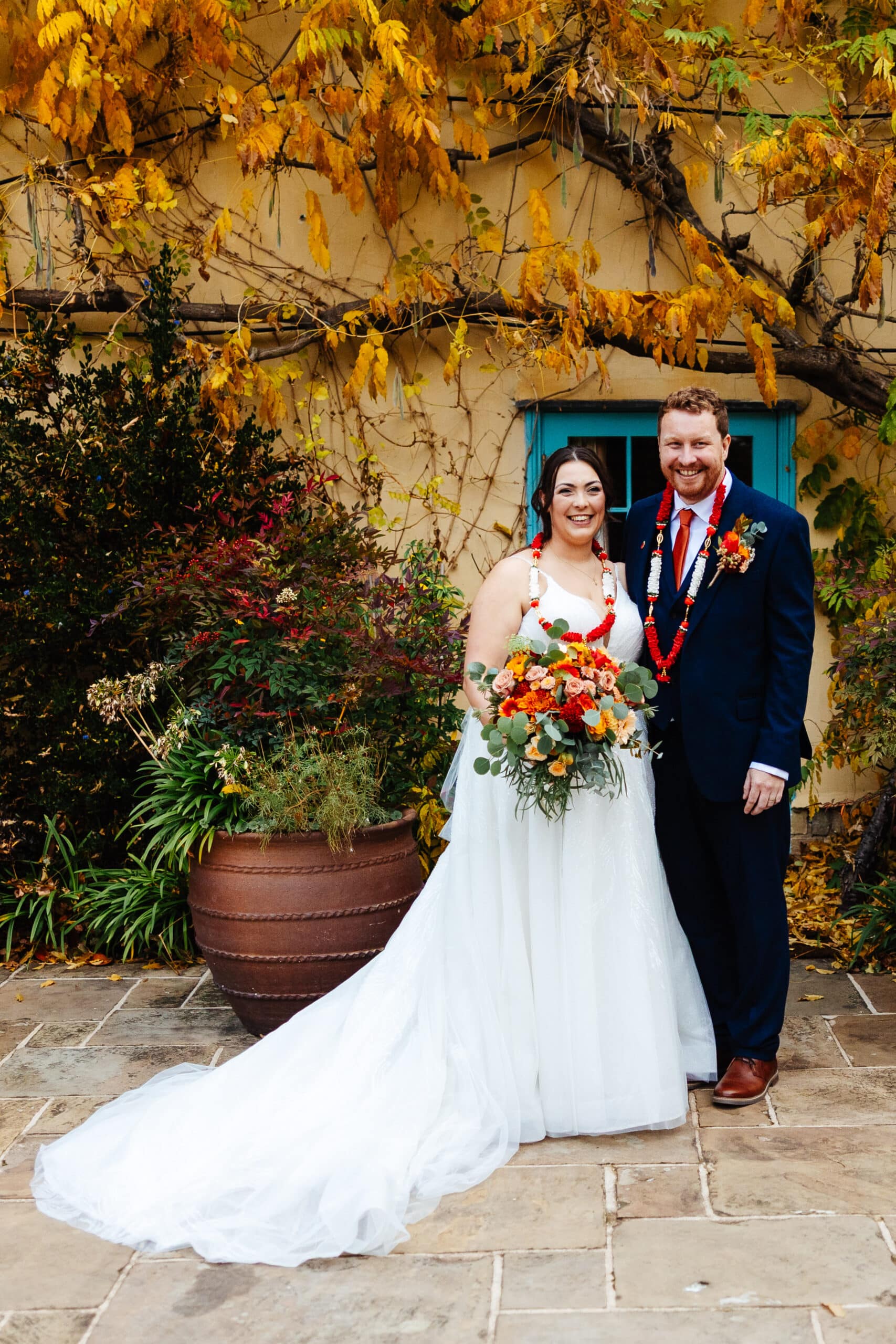 Couple posing with wedding attire outdoors.