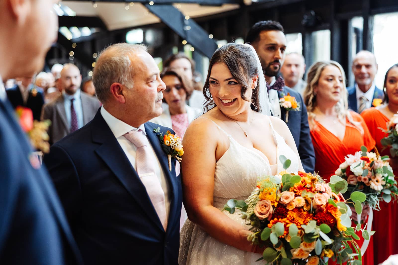 Bride smiling with father at wedding