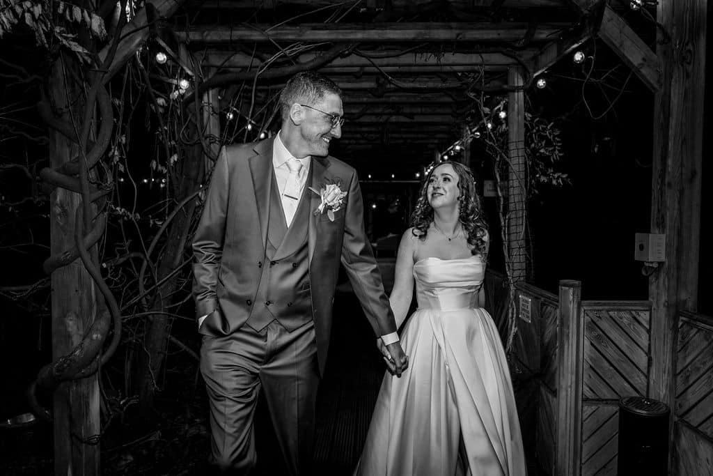 Couple walking hand in hand, smiling.