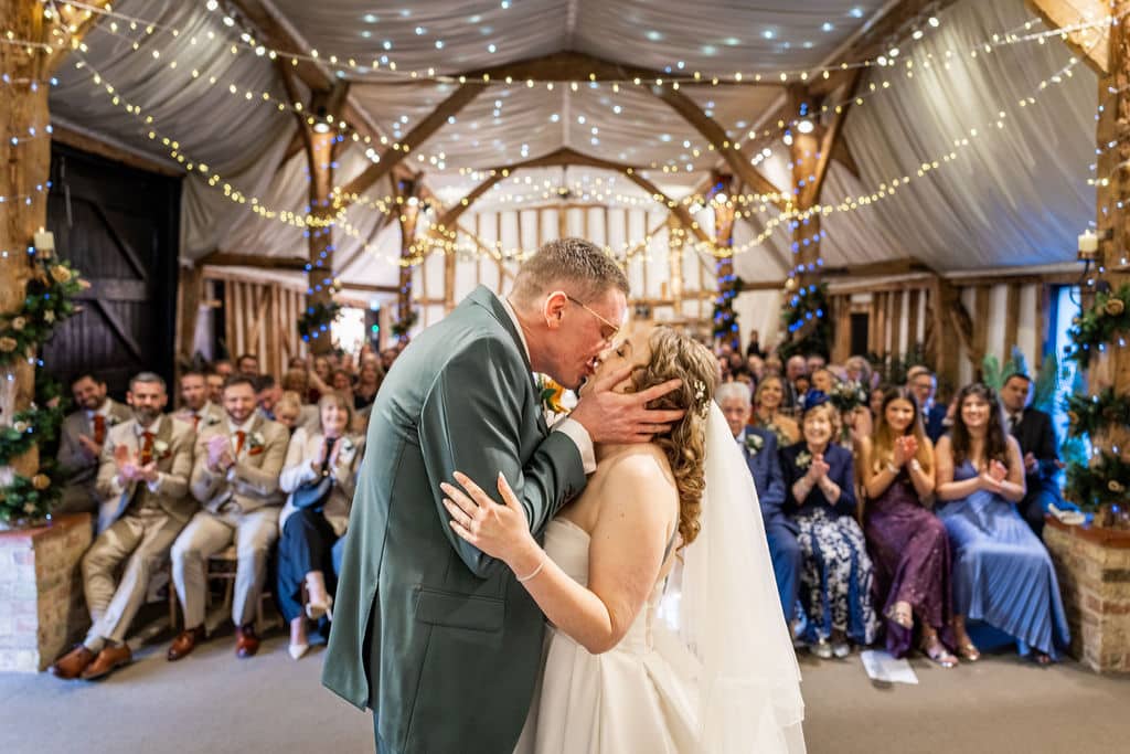 Couple sharing a kiss at wedding.