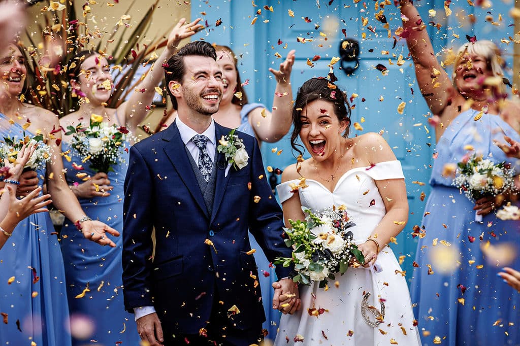 Bride and Groom having confetti thrown at them at intimate barn wedding venue