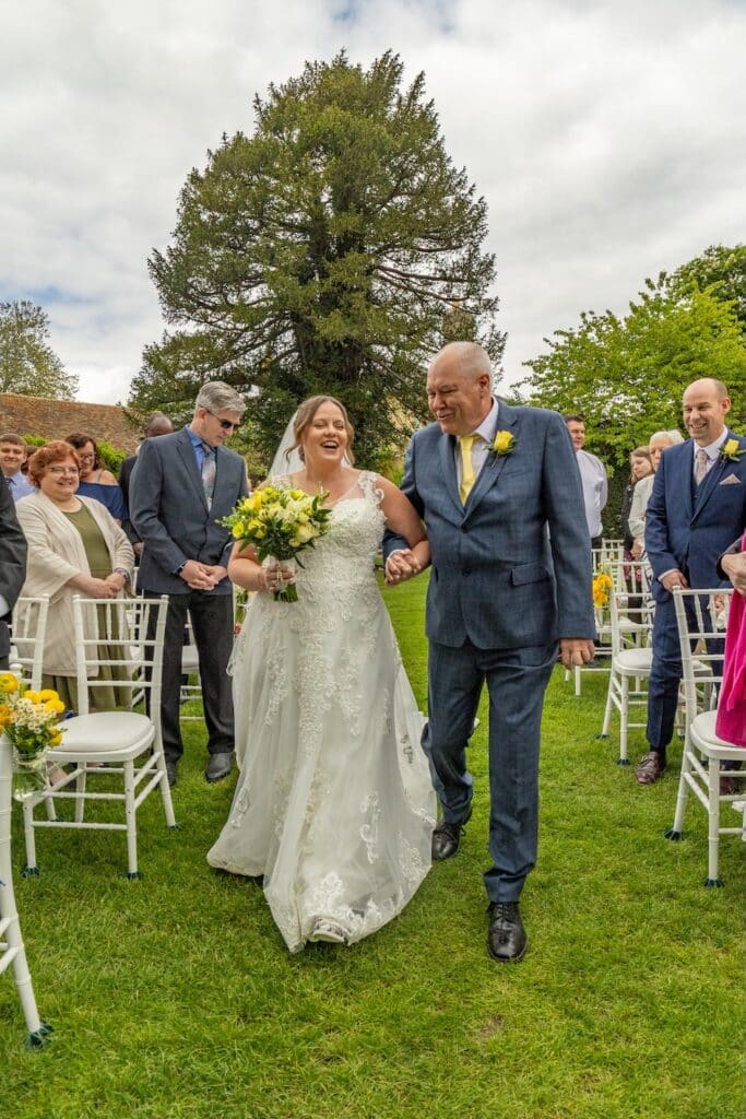 Father of the Bride walks bride down the aisle and outdoor garden wedding venue